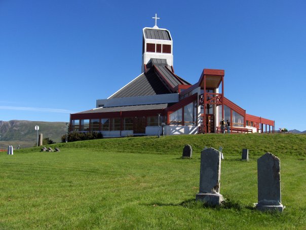 Bilde av Borge kirke, bygd 1987, under blå himmel.